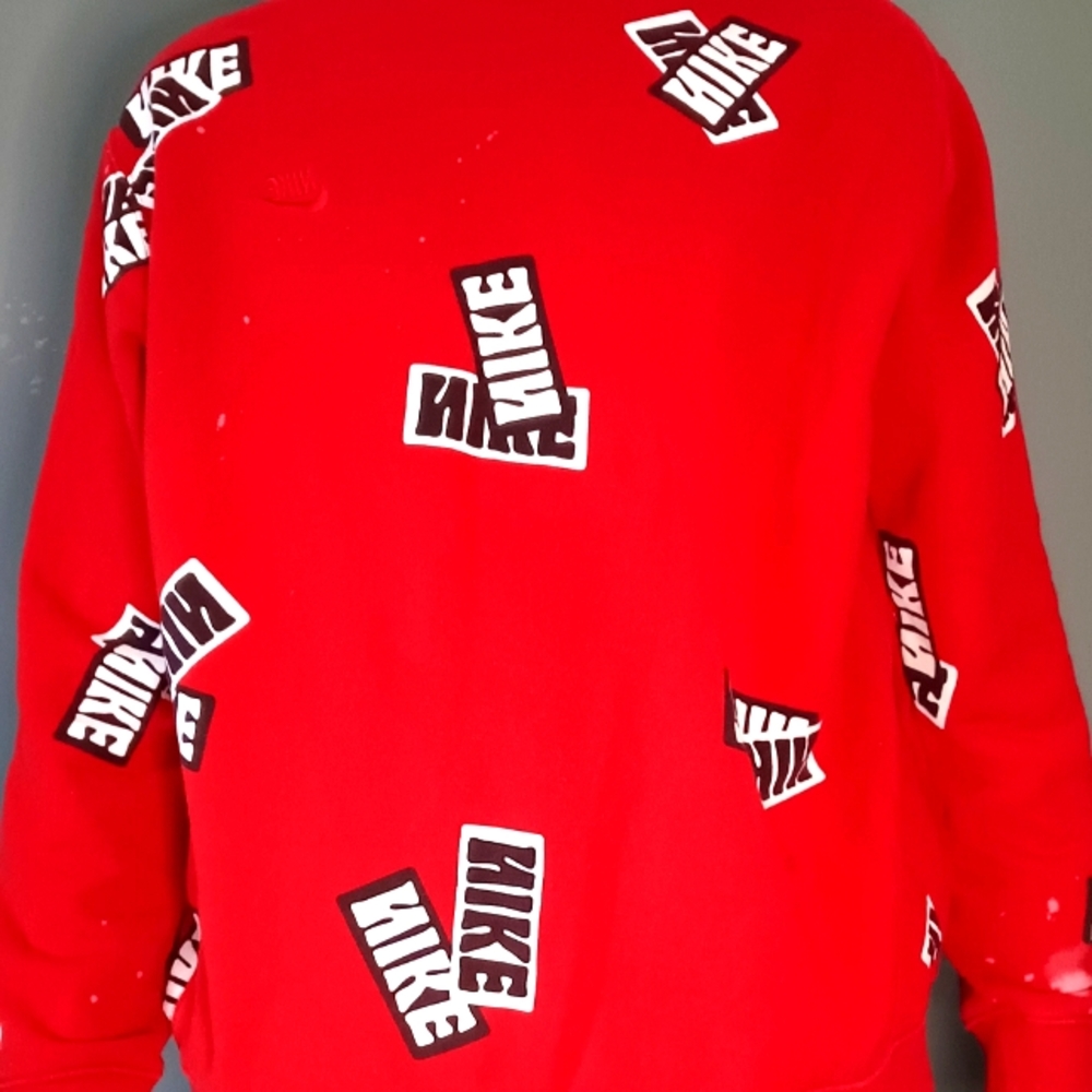 Nike Sport Essentials all over sticker print crew neck fleece sweatshirt in red